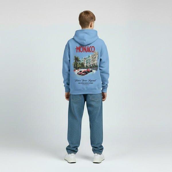 Hoodie bleu Monaco GP enfant, vue de face, capuche baissée, logo poitrine, coupe ample, mains relâchées, fond studio gris.