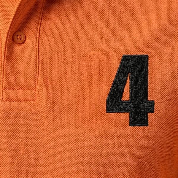 Nahaufnahme der schwarz gestickten 4 auf dem Lando Norris Polo in Orange