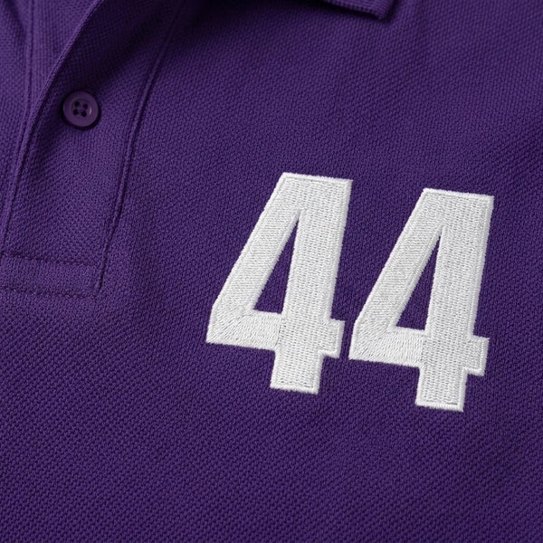 Nahaufnahme der weiß gestickten 44 auf dem Lewis Hamilton Polo in Violett