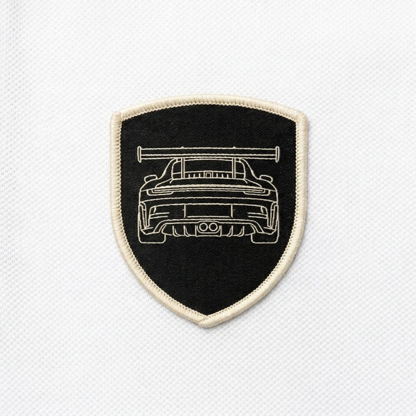 Nahaufnahme des gewebten GT3 RS Patches auf dem Polo in Weiß