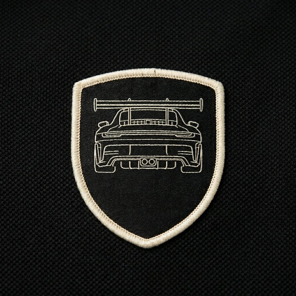 Nahaufnahme des gewebten GT3 RS Patches auf dem Polo in Schwarz