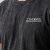 Nahaufnahme des Tourismo-Logos auf der Brust des Washed-T-Shirts