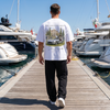 Homme portant le t-shirt blanc Concours Circle 300 SL sur un ponton de marina en plein jour